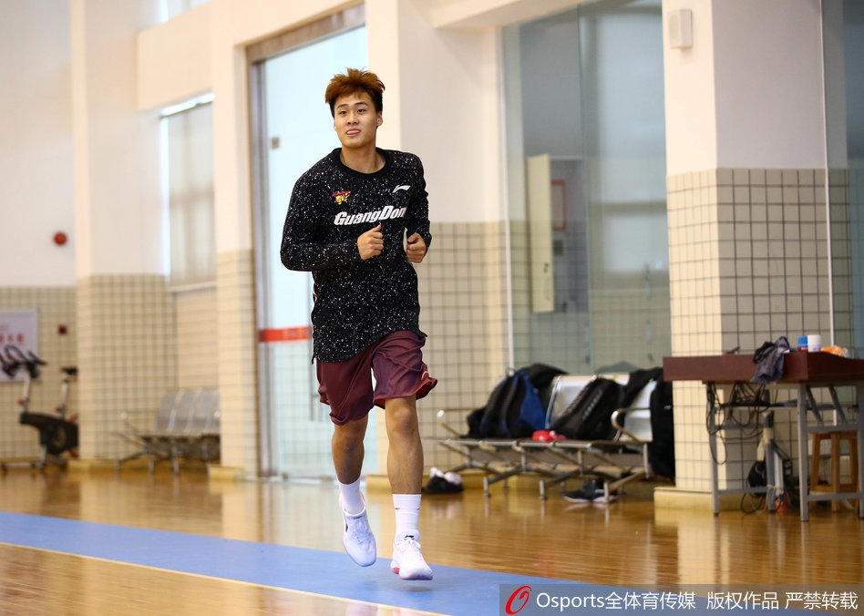 莫里斯身穿广东宏远训练服，在赛前热身中神情专注，拉伸筋骨，为即将到来的首秀做最后准备。