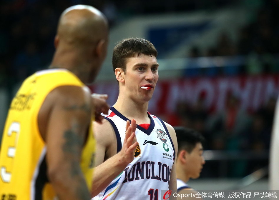 面对北控队员的贴身防守,汉斯布鲁弯腰运球突破,嘴角的血迹在灯光下格外醒目,对手的表情也显得凝重。