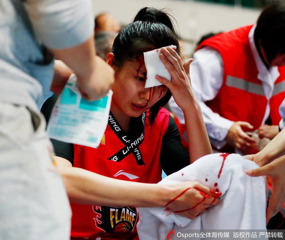 终场哨响，队友们在场上激烈角逐，而场边的郭子瑄头部缠着厚厚的染血绷带，眼神复杂地注视着这一切，这一刻她的坚韧与无奈令人动容。