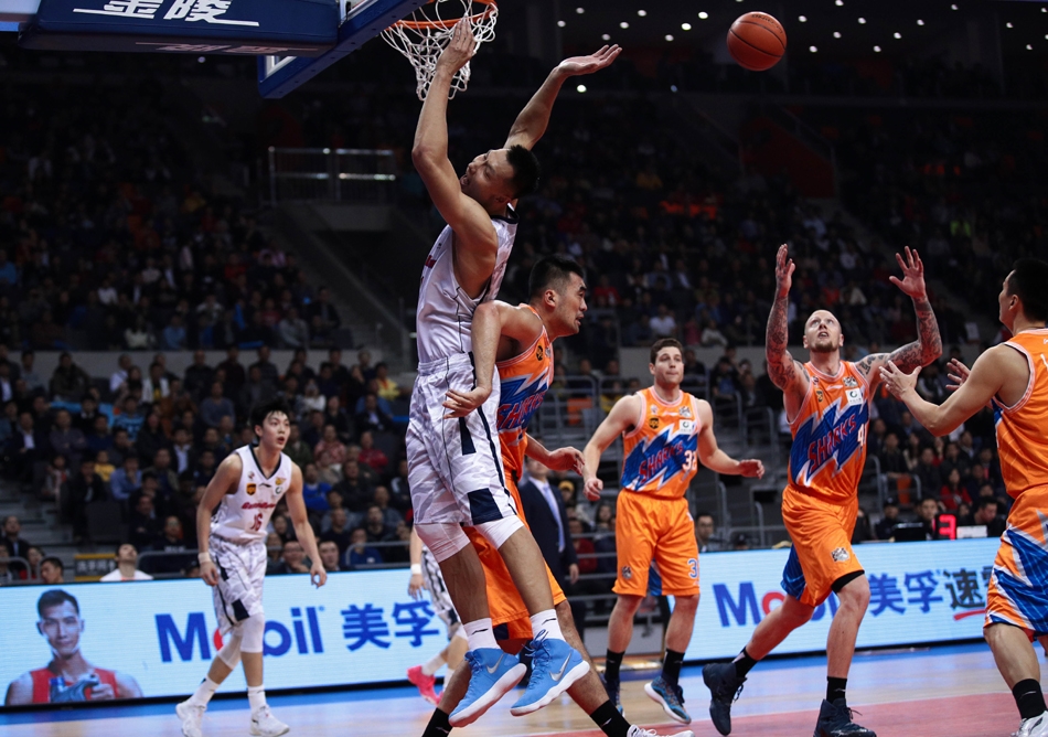 易建联在对手的严密防守下依然冷静出手，篮球在空中划出完美弧线