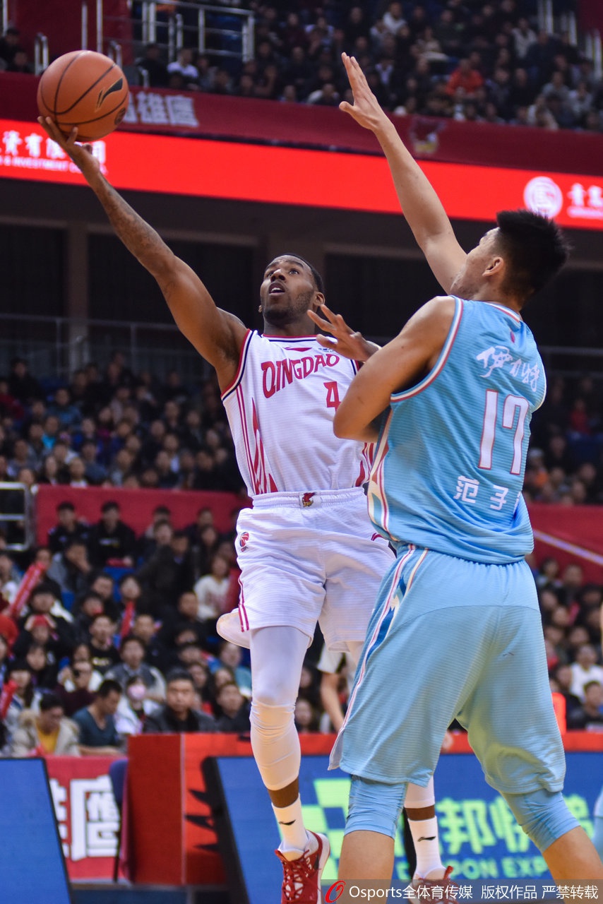 亚当斯在新疆队多名球员的围堵下强行突破，眼神坚毅，高高跃起试图完成高难度上篮