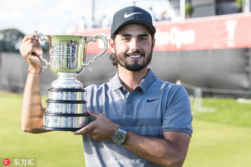 亚伯拉罕·安瑟在第十八洞果岭推入制胜一推后，振臂高呼，阳光洒在他激动而坚毅的脸庞上。