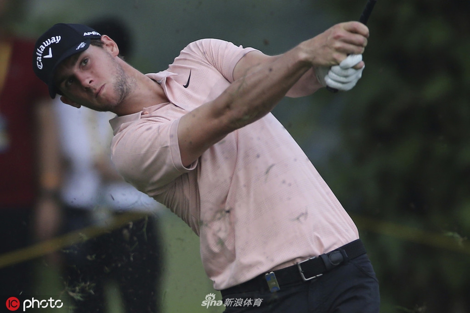 澳大利亚球手马库斯-弗雷泽在吉隆坡球场上专注地审视推杆线路，神情冷静