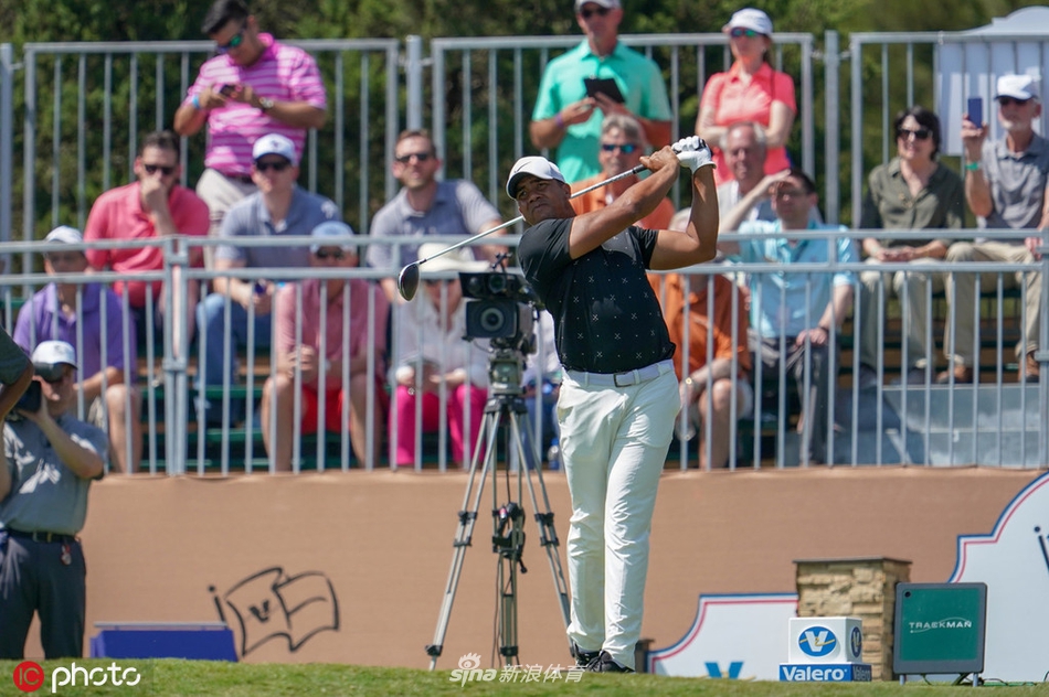 球迷们聚集在果岭周边，聚精会神地观看球员推杆，沉浸在高尔夫运动的魅力之中。