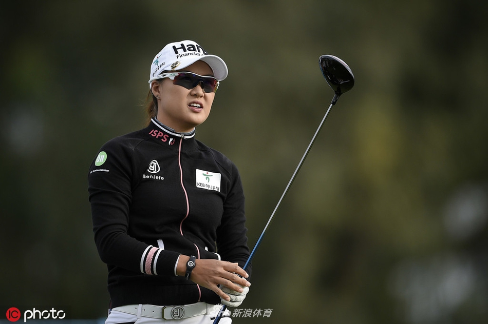 领先者阿莉·麦克唐纳德在18号洞果岭沉稳观察推杆线路，身后是标志性的波比池与棕榈树