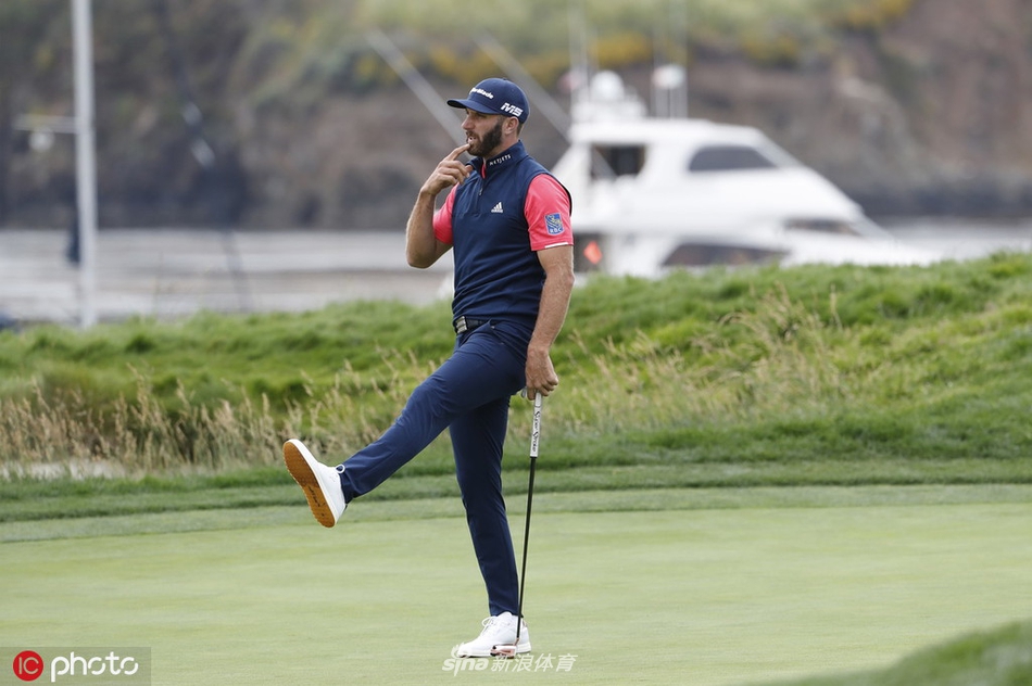 泰格·伍兹在圆石滩经典的第七洞三杆洞,迎着海风全神贯注地准备开球,远处礁石与海浪构成标志性背景。