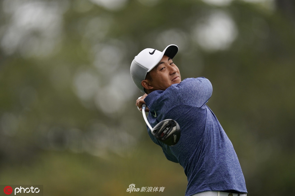 里奇·福勒在果岭旁长草中冷静观察切杆线路,表情专注,阳光洒在果岭上形成明暗对比。