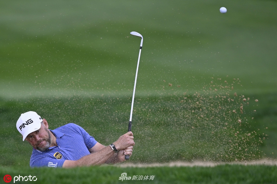 亚历山大·维斯伯格在湖畔三杆洞开球，水天一色的背景中，其挥杆姿态稳定而协调，小球径直飞向果岭中心。