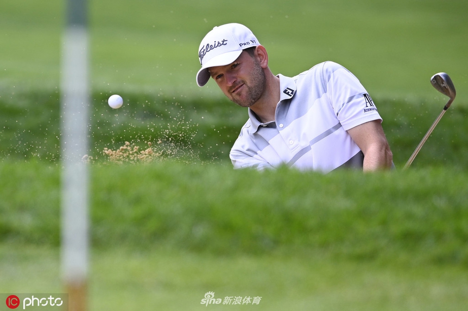 托马斯·皮特斯在球道沙坑中奋力一击，沙砾飞扬瞬间捕捉到他全身发力与专注的神情，小球精准飞向果岭旗杆。