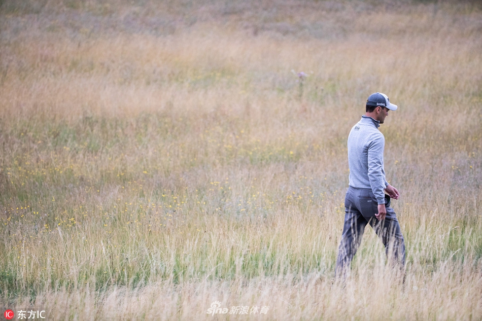 德国名将马丁-凯梅尔在球道上优雅地挥动铁杆，阳光勾勒出他标准的击球姿势