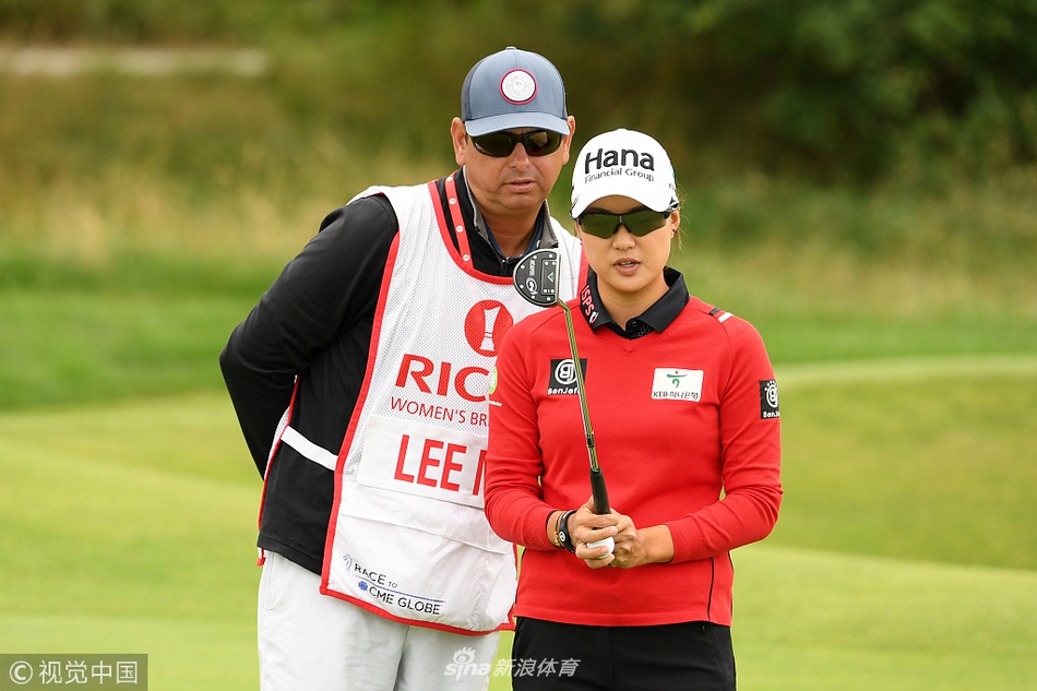 伯娜隆在果岭边仔细阅读推杆线路，神情专注，手中握着那枚标志性的粉色高尔夫球。