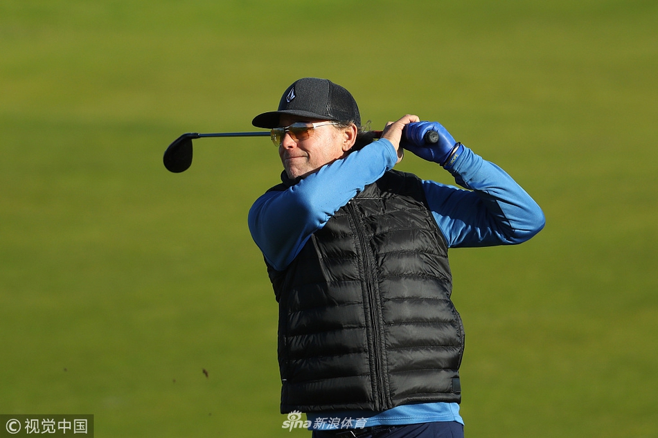 莱德杯赛场全景,夕阳余晖为绿草、沙坑和簇拥的观众披上了一层金色的荣耀薄纱。