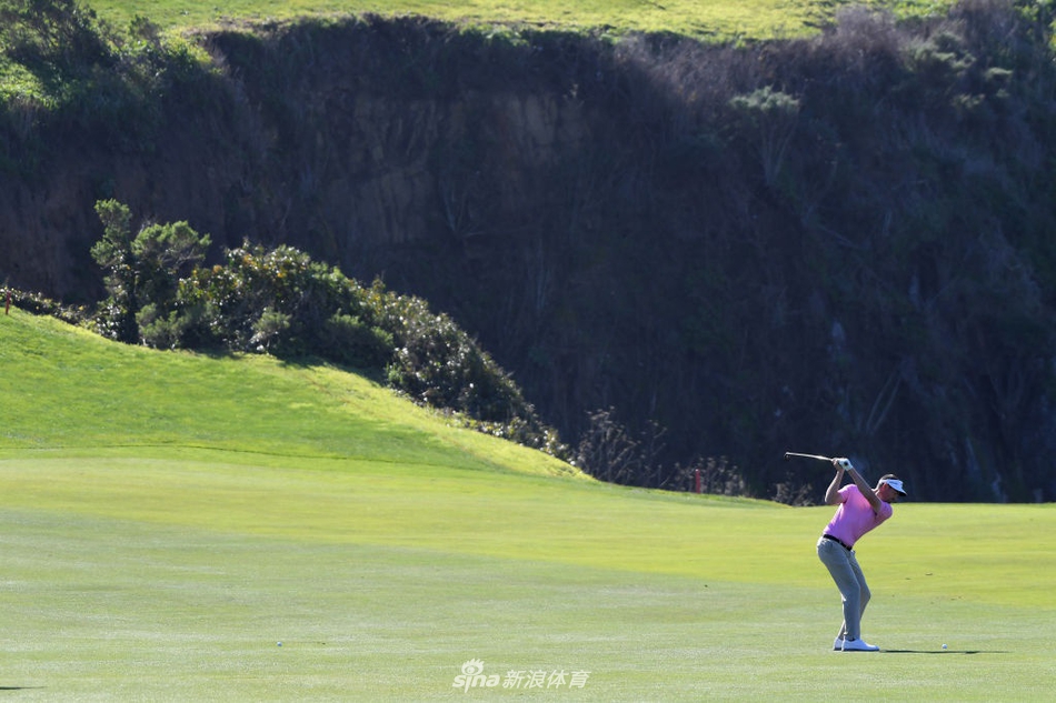 比赛现场强风肆虐,米克尔森的帽子被吹起,他正奋力挥杆与恶劣天气对抗。