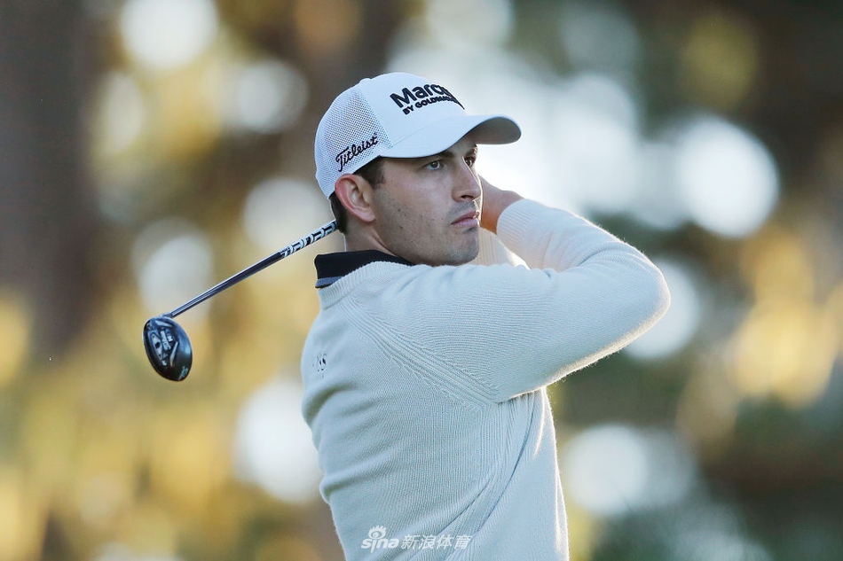 尼克·泰勒在全神贯注地推击,背景是典型的林克斯风格沙坑和远处湛蓝的海岸线。