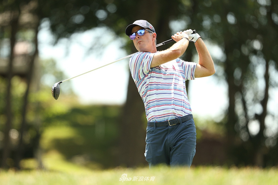 布兰登-托德全神贯注，在果岭边细致观察推杆线路，眼神中充满对胜利的渴望。