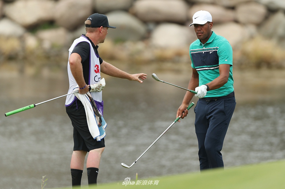 汤普森在沙坑中救球后与球童默契击拳，空荡的观众席让这无声的庆祝更显选手与球童间的信任