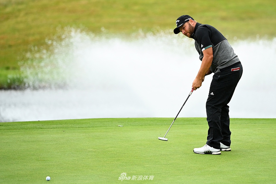 观众身穿五彩雨衣聚集在球场山坡上,如同风雨中绽放的花朵,聚精会神观看山下果岭的比赛。
