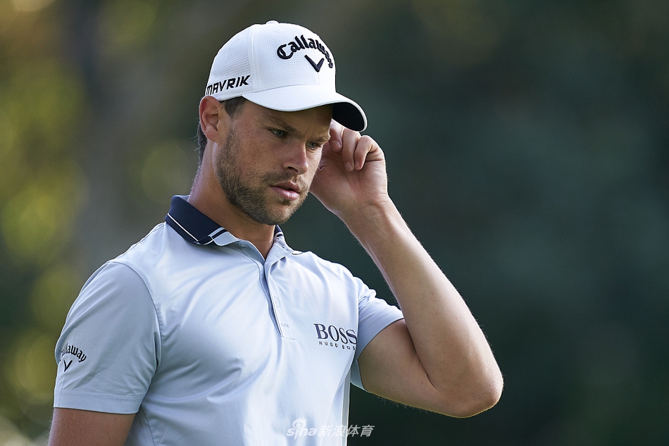 托马斯-德迪凝神注视小白球,在果岭边缘准备关键推杆,身后是安达卢西亚典型的湛蓝晴空与连绵绿茵