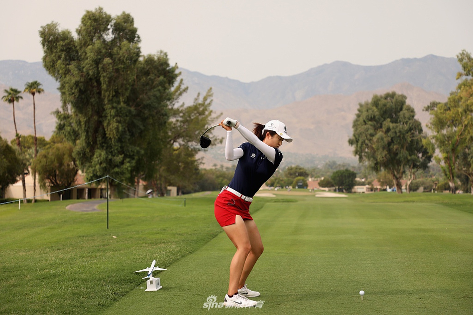 球员在超过100华氏度的烈日下撑着遮阳伞行走在球道,远处天空因山火烟霾显得有些朦胧