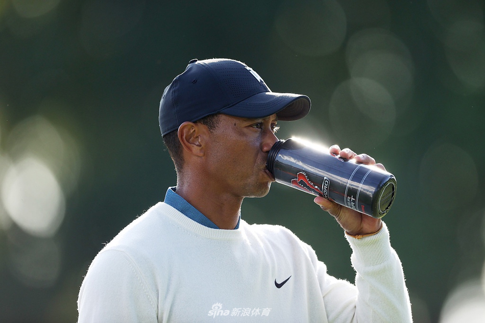 伍兹从沙坑中奋力一击，沙粒飞扬，展现他永不放弃的拼搏精神。