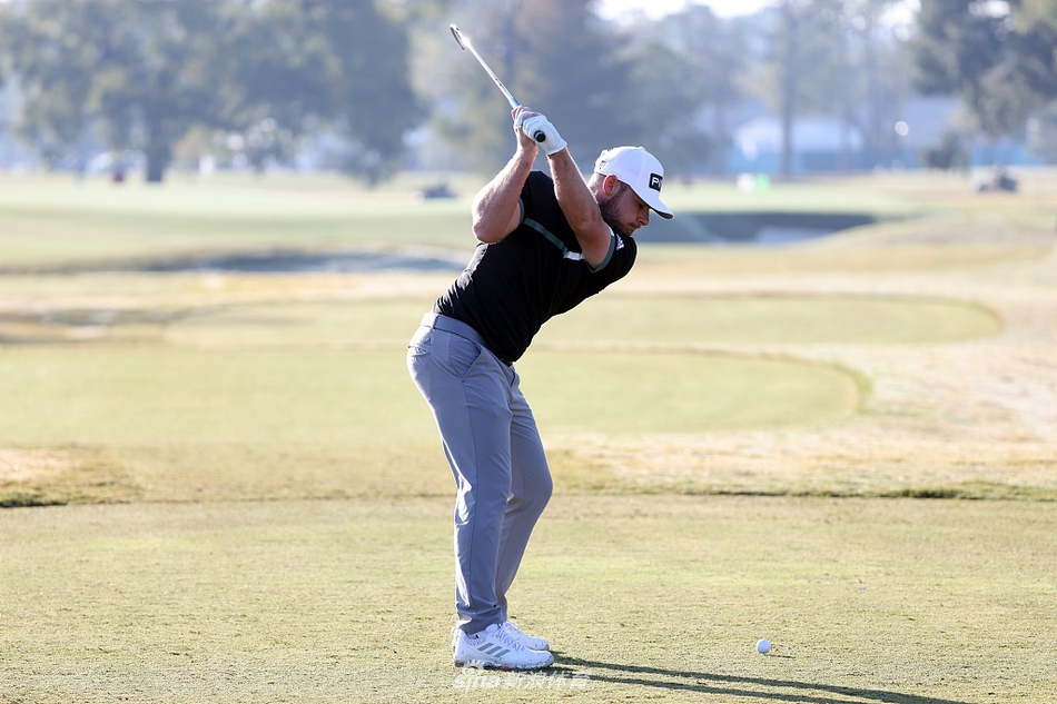 简森·戴伊完成一次漂亮的挥杆，身体姿态舒展有力，球杆在阳光下划出银色弧线