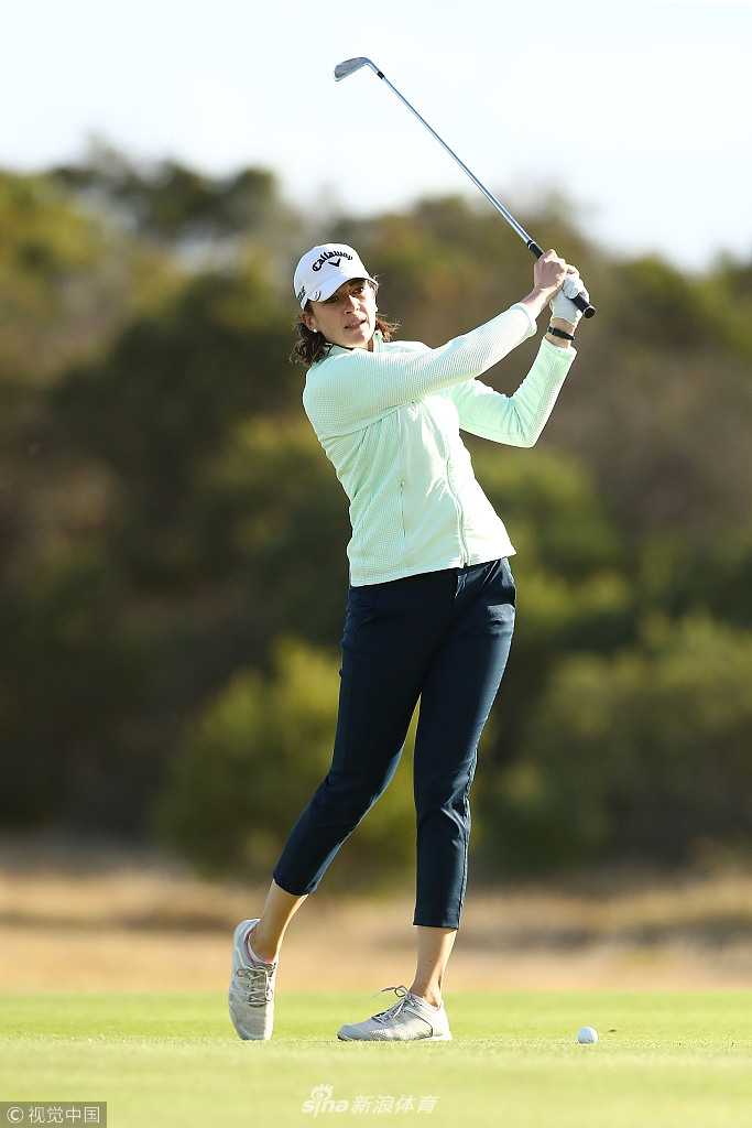 金·考夫曼在果岭边审慎观察推杆线路，海风拂动她的发丝，展现女子比赛中的坚韧与细腻。