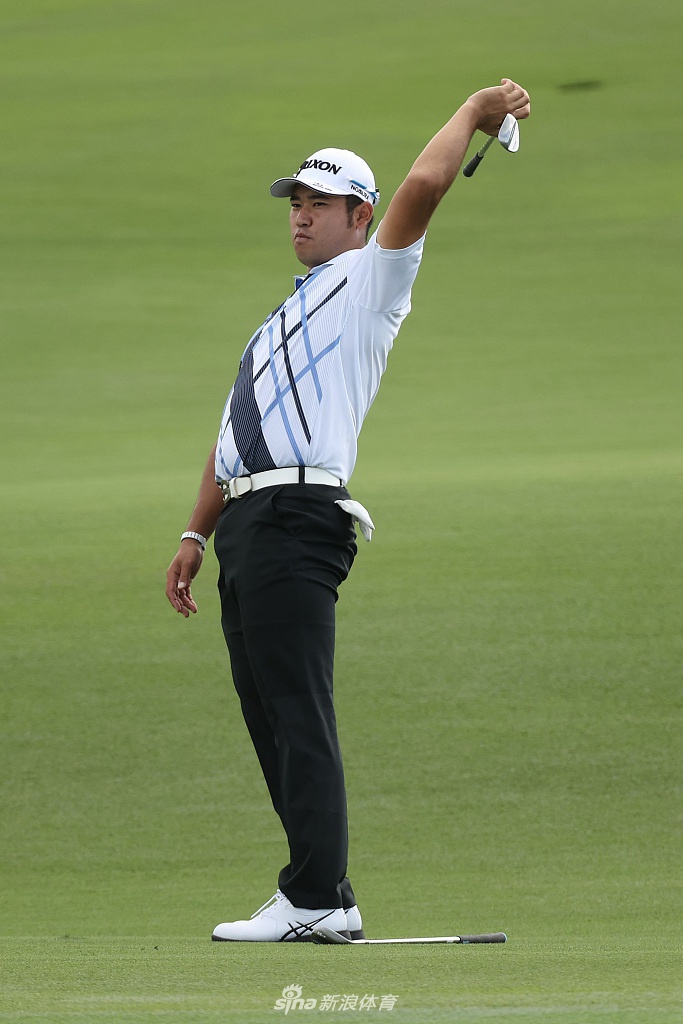 松山英树在练习果岭上凝神推击，表情专注而沉静