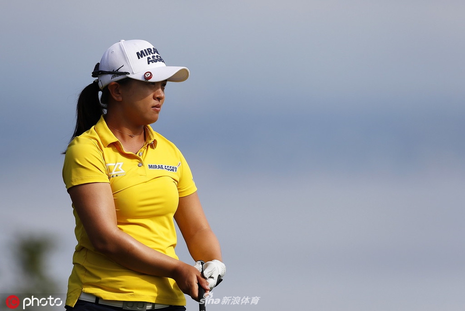 观众聚集在风景如画的湖景球洞旁，聚精会神地观看比赛，享受着高尔夫运动与自然美景融合的独特魅力。