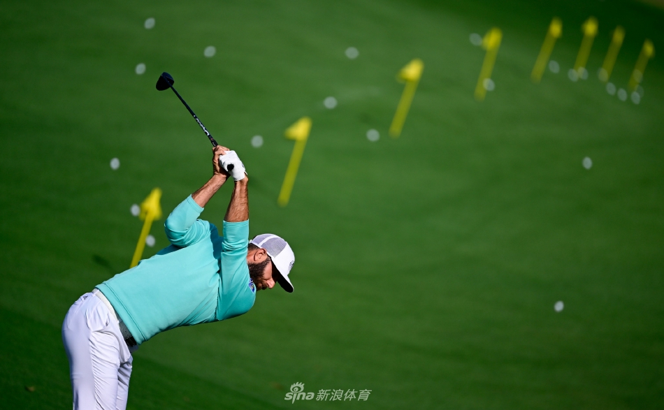 晨曦笼罩下的奥古斯塔第12洞果岭，金合欢树在薄雾中若隐若现，宁静的球场等待着今日的首批传奇到访。