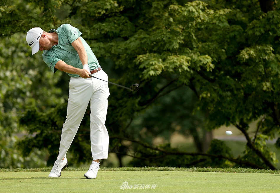 贾斯汀·托马斯在球道沙坑中奋力救球，沙砾飞溅，展现世界顶级球员逆境下的专注与力量