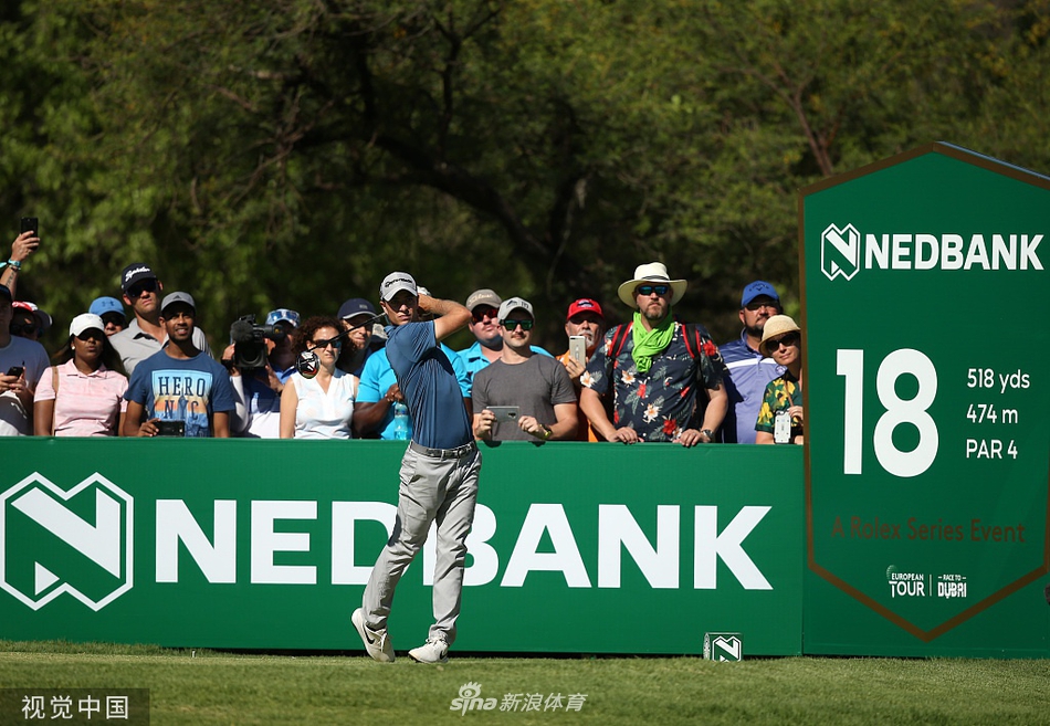 赛事观众聚集在果岭周边，聚精会神地观看球员推击，现场气氛宁静而紧张。