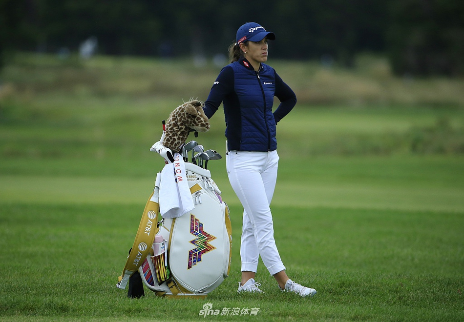 观众聚集在果岭周围，屏息凝神观看选手推杆，赛场气氛紧张而热烈。