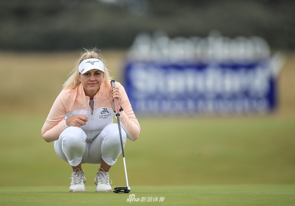 奥莉维亚-考恩迎着海风全力开球，球杆与身形划出流畅曲线