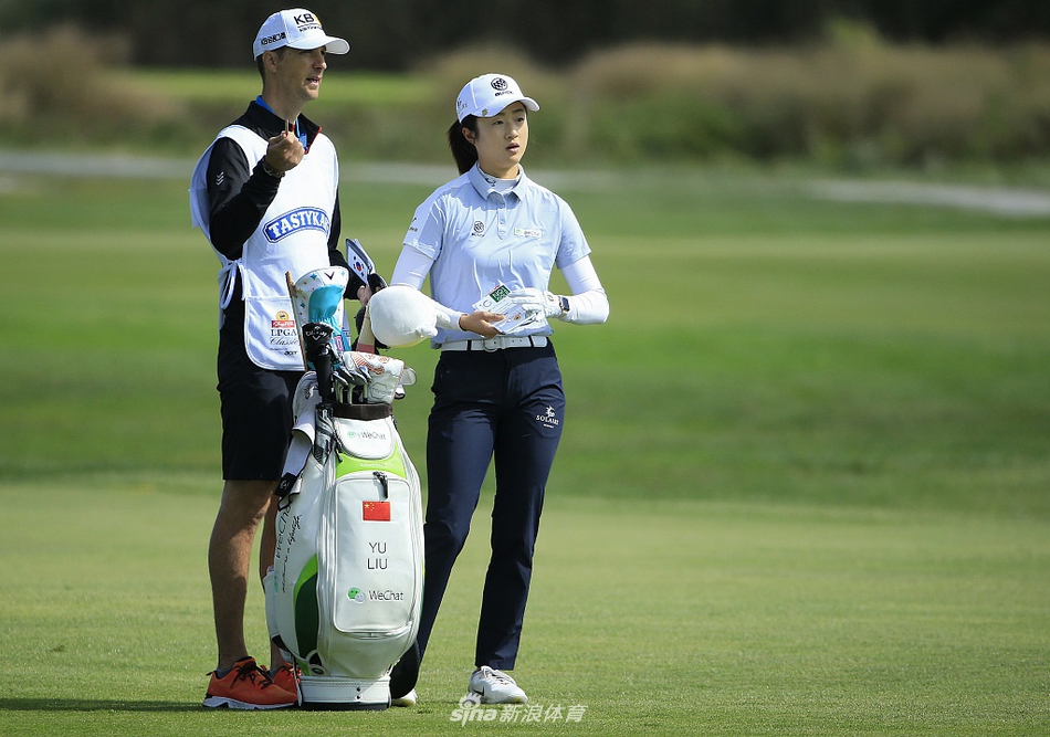 赛琳-伯蒂尔果岭边优雅切杆，沙坑杆划出完美弧线，小球直奔旗杆而去。