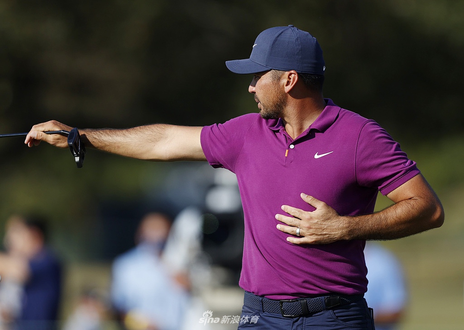 高尔夫球在空中飞向果岭，背景是湛蓝天空与球场标志性的景观