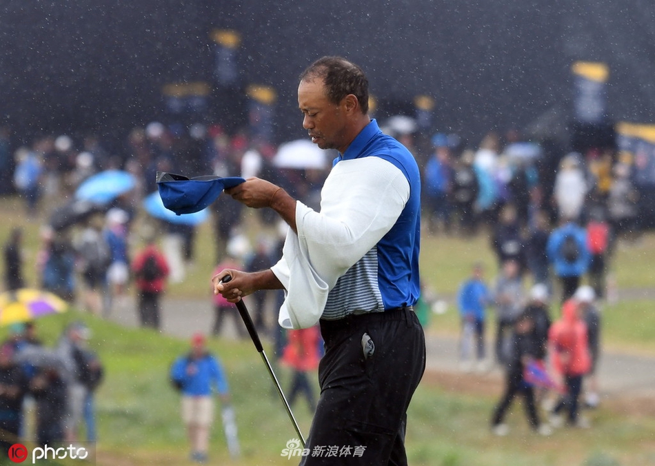 伍兹在果岭边沙坑中救球,沙粒被高高溅起,他全身肌肉紧绷,专注地完成这记需要精准触感的沙坑击球。