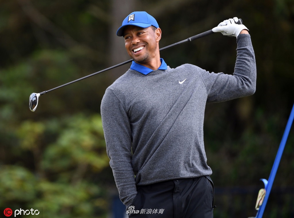 伍兹在糟糕的击球后流露出短暂的沮丧表情,他低头看着地面,手中球杆紧握,完美展现了竞技体育中压力与挫折的真实一面。