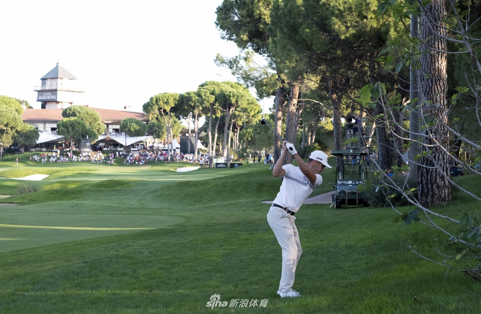 果岭旁沙坑挑战重重，一位球手正仔细斟酌如何将球从细腻的白沙中救出。