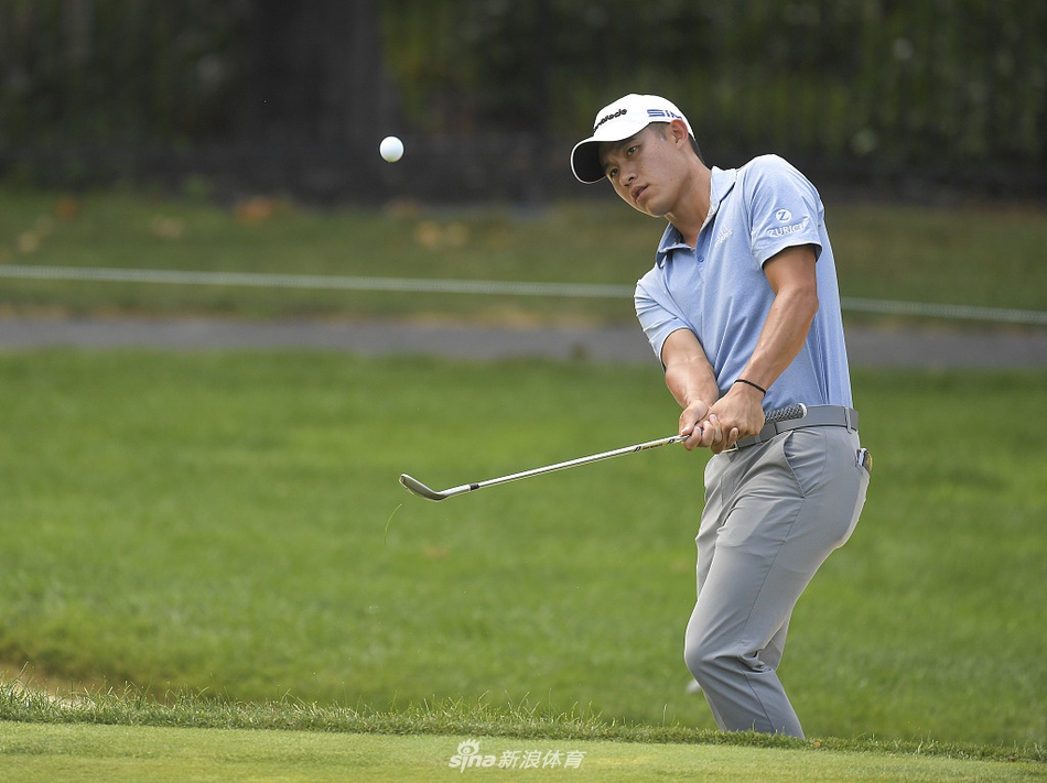 科林-森川在穆菲尔德山村赛场上专注地凝视球道，阳光洒在肩头，神情坚定