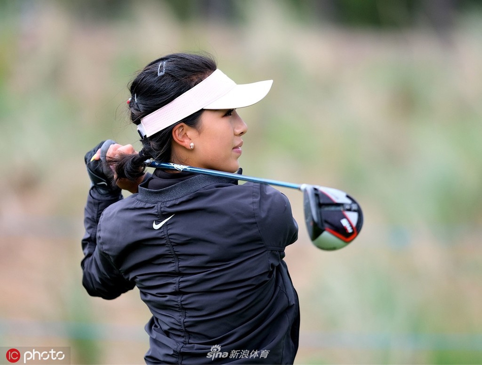 何沐妮在球道上漫步，身后是苏格兰开阔的球场与天空