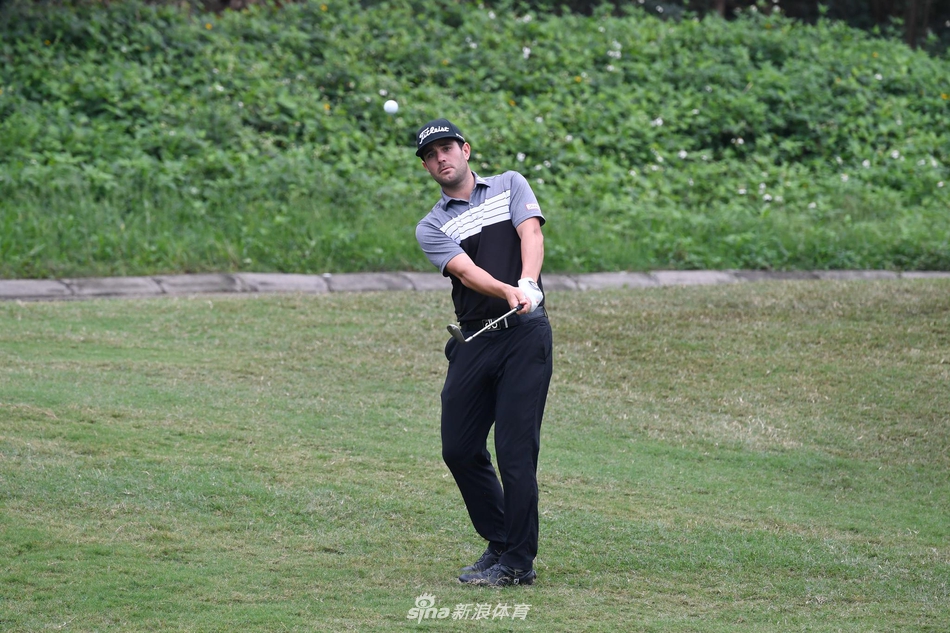 球员在发球台蓄力开球，身体扭转至完美角度，球杆与身影在草地上划出动态弧线