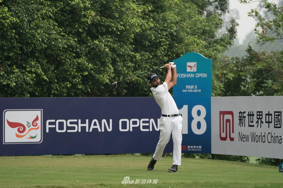 观众聚集在果岭周围,屏息凝神观看球员推杆,现场气氛紧张而热烈。