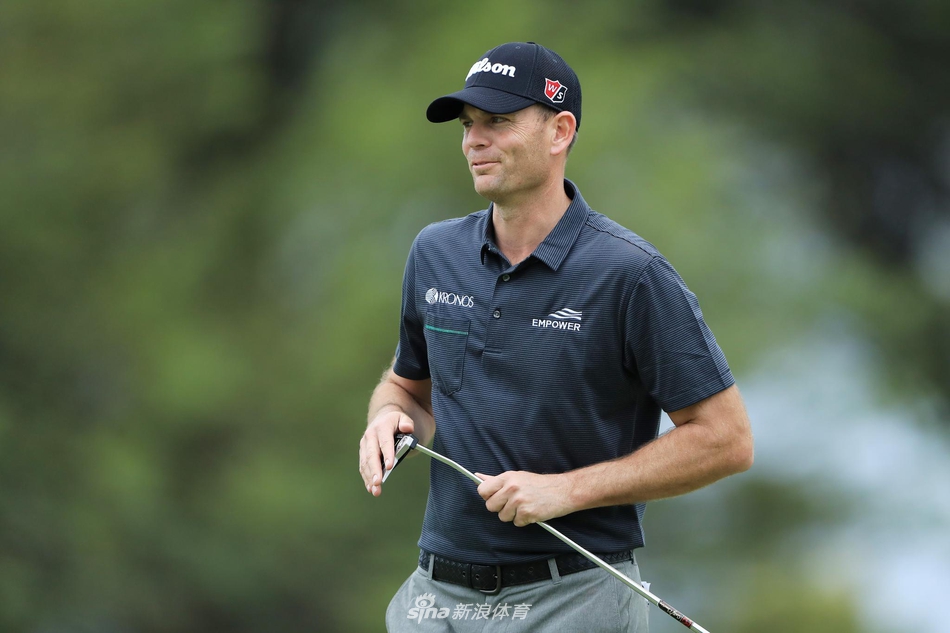 韦伯·辛普森在雨中撑着伞观察果岭形势,雨丝划过伞沿,他沉稳的表情体现了老将面对恶劣天气时的丰富经验与耐心。