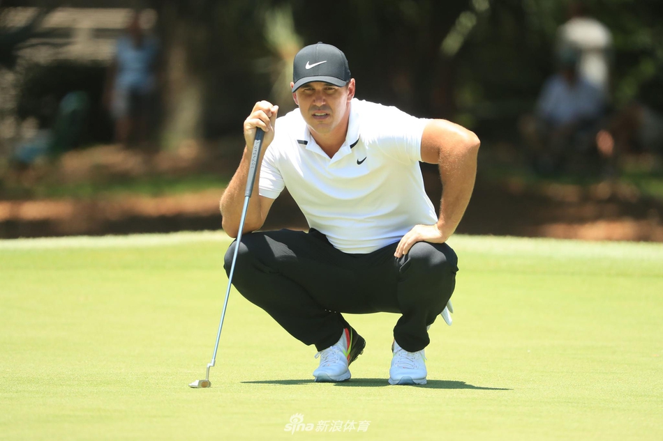 观众站在标志性的灯塔背景下远眺球场，传承高球赛的经典场景与激烈的比赛融为一体