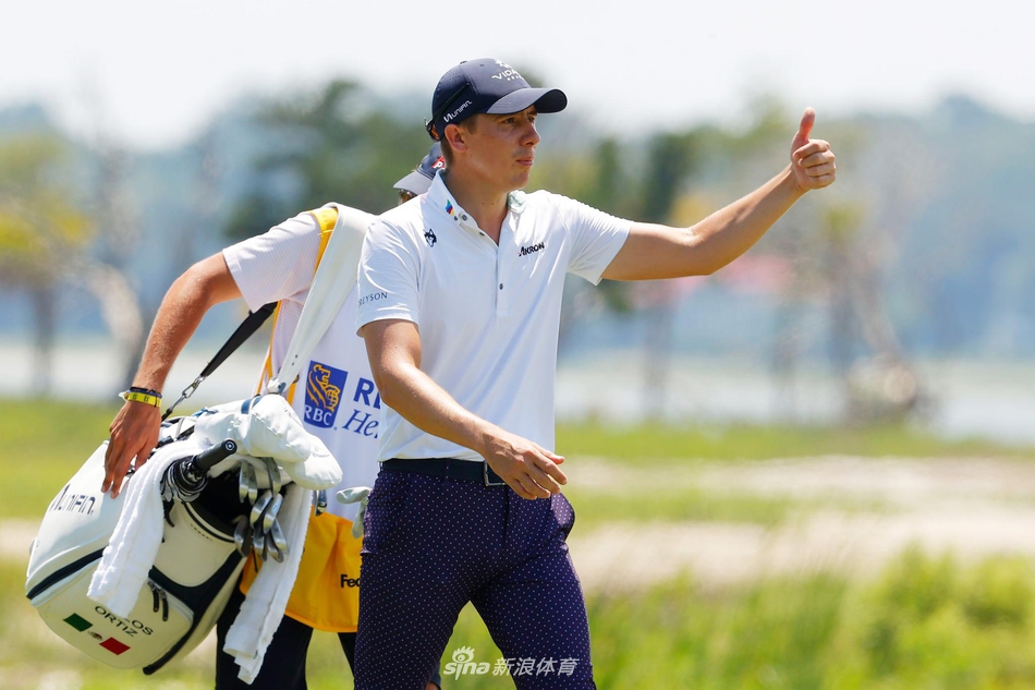 达斯汀·约翰逊在发球台上全力挥杆，身体充分扭转，白色小球如炮弹般飞向远方的球道