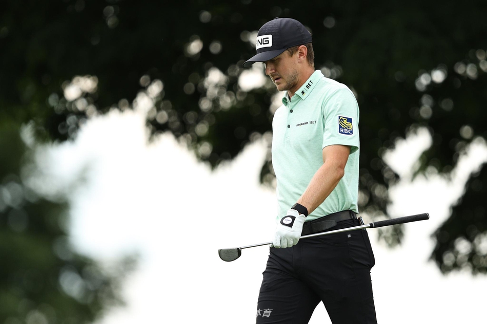 麦肯兹-休斯俯身进行关键推杆，果岭纹路清晰可见，全场屏息凝神