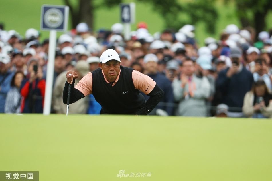 伍兹在南丘乡村俱乐部果岭边凝神观察，眉头紧锁，专注中透露出身体不适的迹象。