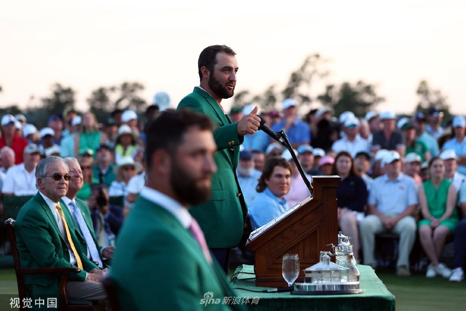 舍夫勒身着经典绿夹克，手捧大师赛奖杯，在奥古斯塔第18洞果岭畔露出从容微笑
