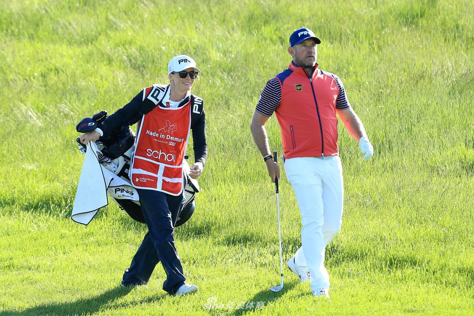 夕阳余晖洒在球场上，一名球童正在果岭上仔细擦拭高尔夫球，为接下来的比赛做准备。