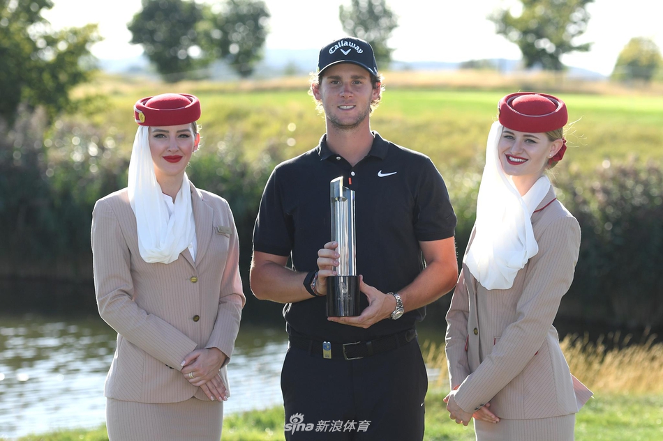 皮特斯与球童并肩前行，在信天翁度假村的葱郁球道上商讨决胜策略